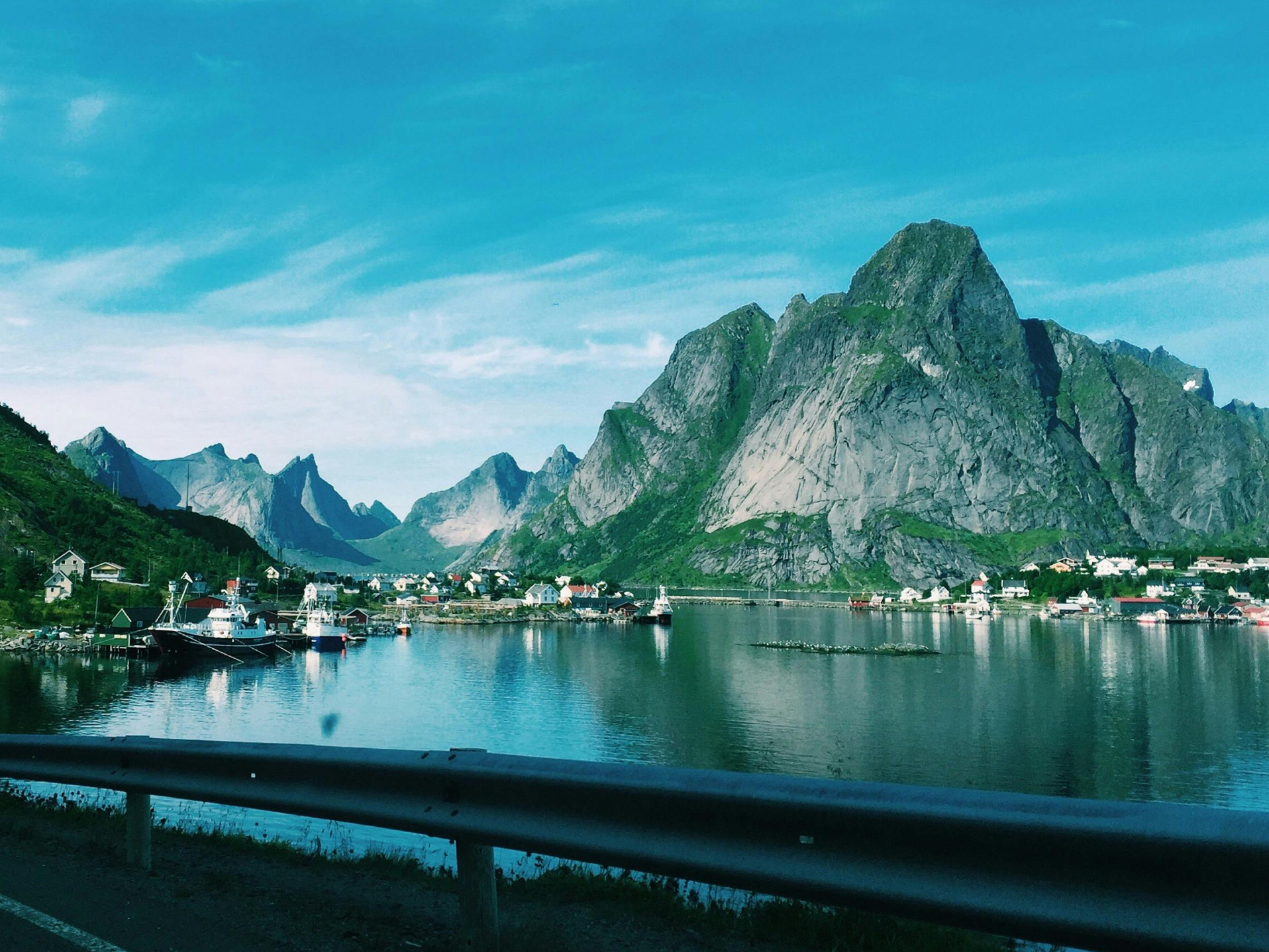 View of a coastal village in Lofoten with steep mountains and blue water